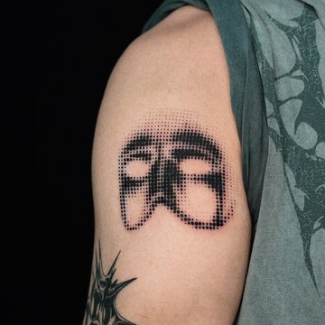 Tatuaż dotwork z maską na ramieniu