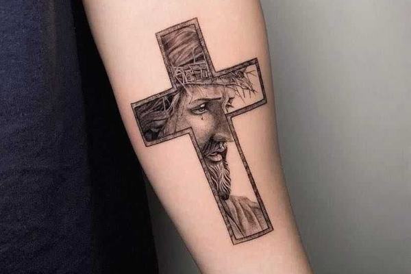 Tatuaż krzyża z twarzą Jezusa na ręce