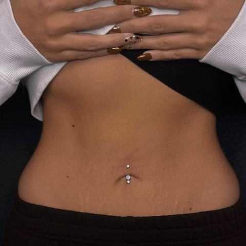 Piercing pępka subtelnie podkreśla linię brzucha. Delikatna biżuteria nadaje całości elegancki blask.