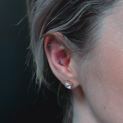 Piercing ucha subtelnie podkreśla jego kształt. Drobna biżuteria tworzy delikatny i elegancki efekt.