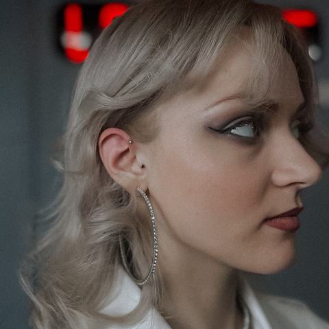 Subtelny piercing brwi podkreśla spojrzenie. Drobna biżuteria nadaje całości nowoczesny charakter.