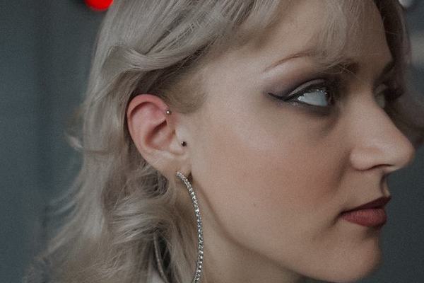 Piercing ucha z elegancką biżuterią u kobiety z blond włosami