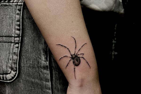 Tatuaż pająka na przedramieniu, widoczny akcent stylu