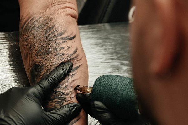 Wykonywanie tatuażu na przedramieniu w VEAN TATTOO