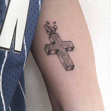 Tatuaż krzyża w stylu drewna na ramieniu