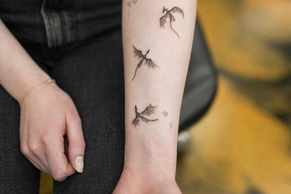 Małe tatuaże smoków na przedramieniu
