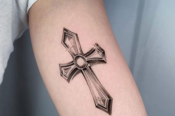 Geometryczny tatuaż krzyża na przedramieniu