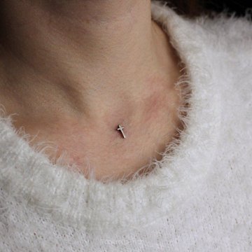 Microdermal na dekolcie – srebrny krzyżyk