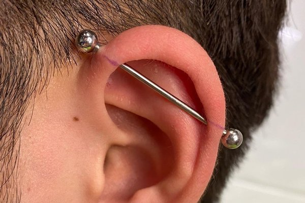 Srebrny piercing industrial w chrząstce ucha