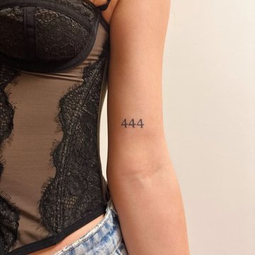 Delikatny tatuaż 444 na ramieniu