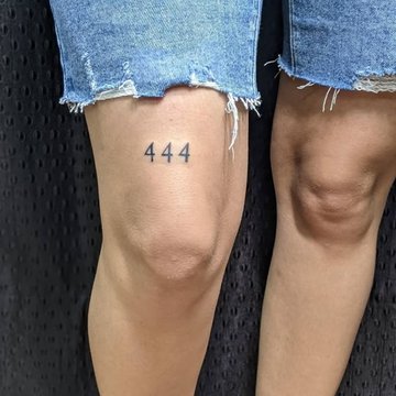 Minimalistyczny tatuaż 444 nad kolanem