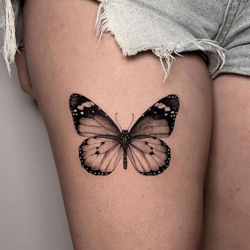 Tatuaż motyl na udzie w delikatnym stylu