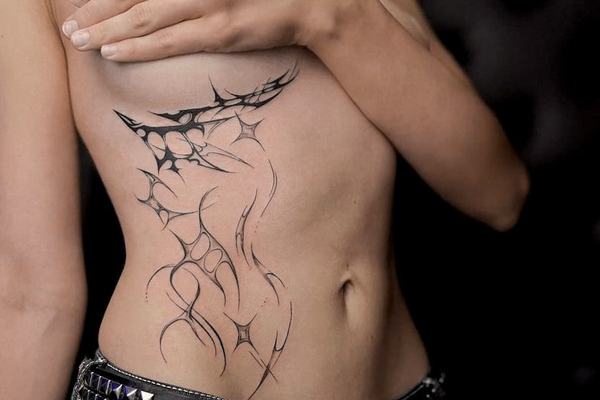 Świeży tatuaż na boku — unikaj tarcia przy gojeniu