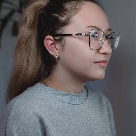 Piercing ucha delikatnie podkreśla profil. Drobna biżuteria dodaje stylizacji subtelnego akcentu.