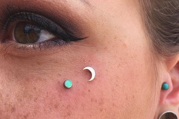 Microdermal pod okiem – księżyc i turkusowa kropka pod okiem – punktowa ozdoba twarzy