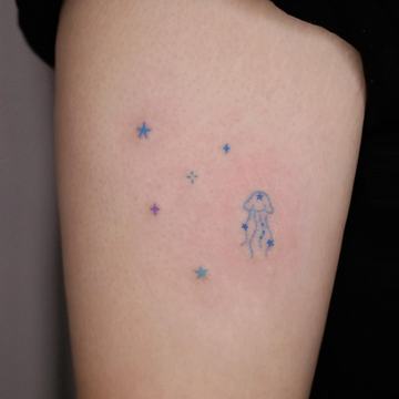 Kolorowy tatuaż z gwiazdkami i meduzą na ramieniu